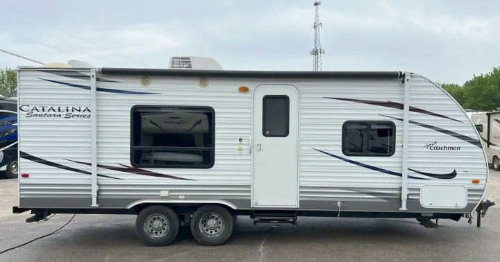 Full side view of a white and gray Coachmen Catalina Santara travel trailer, great for your RV rental.. Coachmen Catalina 2012