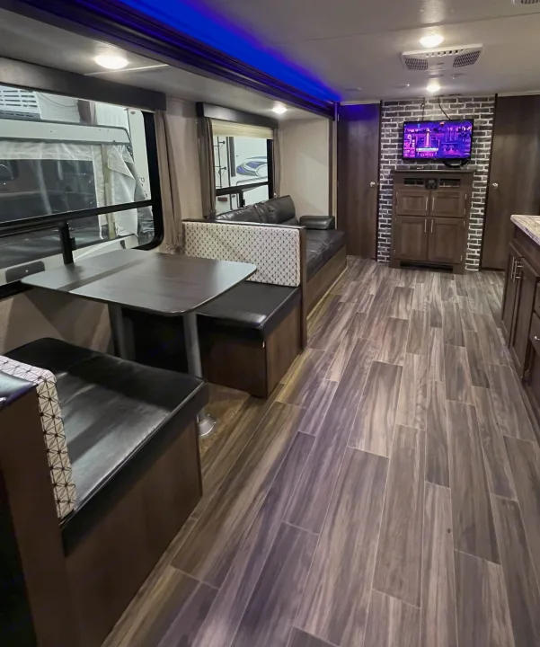Spacious RV rental interior with dinette, couch, kitchen, and wood-look flooring. Ready for your next adventure!. Forest River Shasta 26DB 2020