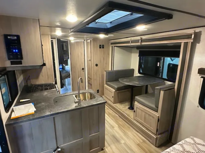 This RV rental interior showcases a full kitchen, comfortable dinette, and bunk beds, ideal for your next adventure.. Coachmen 2146BHX 2023
