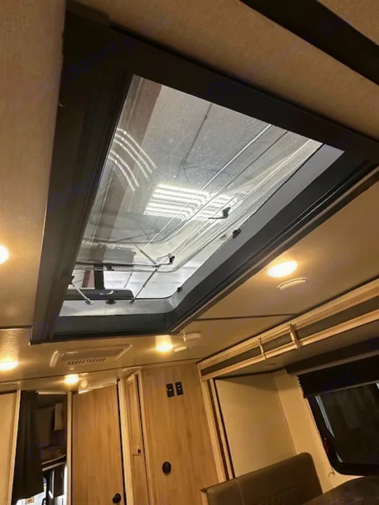 Spacious rv rental interior featuring a large ceiling skylight with mesh screen for ample natural light and ventilation.. Coachmen 2146BHX 2023