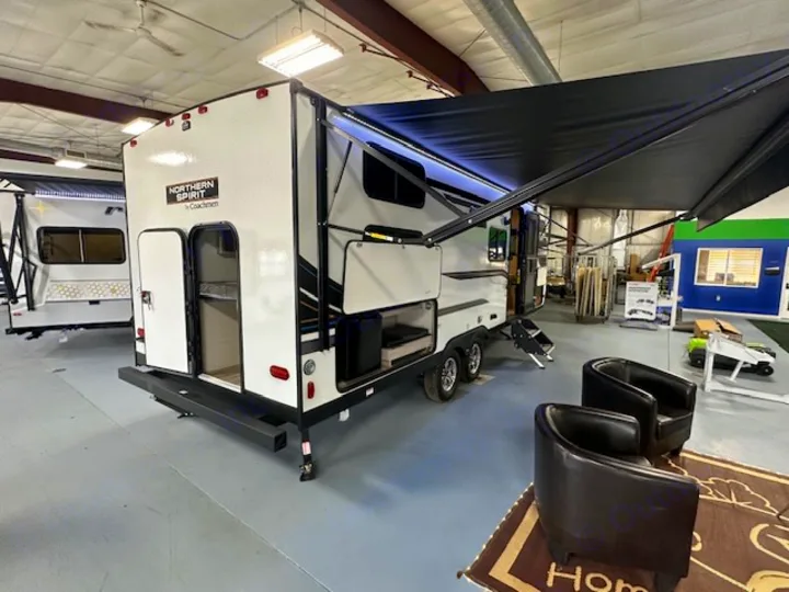 Showcasing a Northern Spirit travel trailer, ideal for your next RV rental adventure, with its extended awning and open storage.. Coachmen 2146BHX 2023