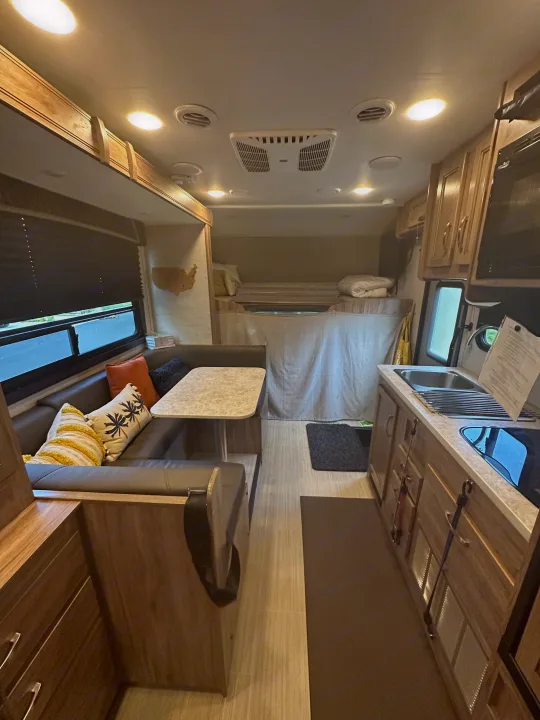 Spacious RV rental interior: cozy dinette, functional kitchen, and comfortable bed for your next adventure.. Jayco Redhawk SE 2021