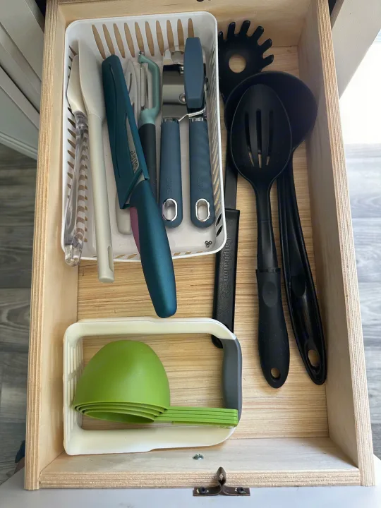 RV rental kitchen drawer: organized with knives, peelers, spatulas, can opener, and measuring cups.. Highland Ridge RV Open Range 2022