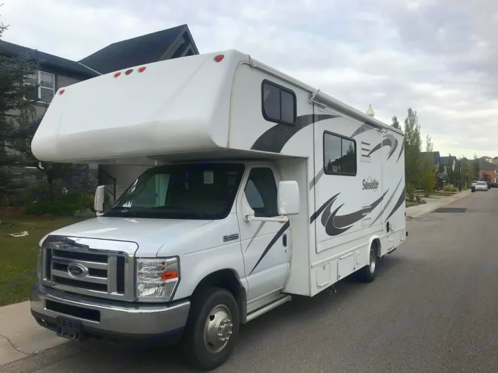 White Ford E-450 Class C RV motorhome on a residential street, perfect for your next RV rental.. Forest River Sunseeker 2008