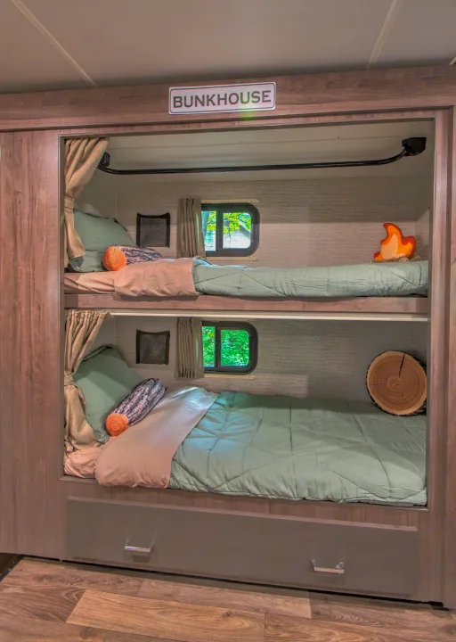 Cozy RV rental bunkhouse with two beds, nature-themed decor, and window views, perfect for a family trip.. Winnebago Minnie Winnie 2021