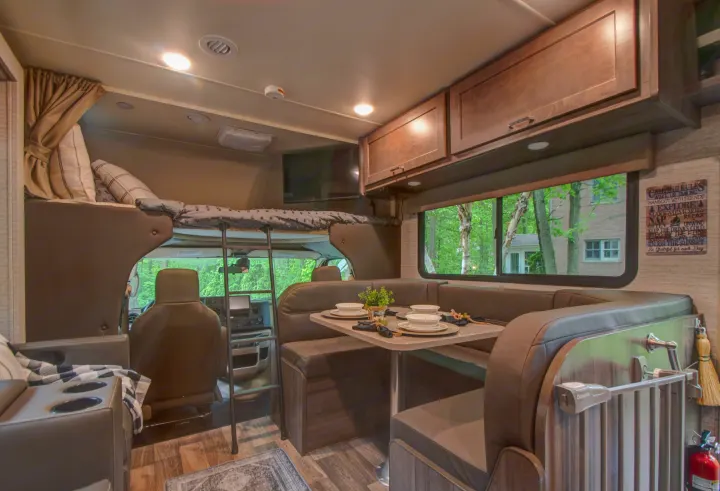 This RV rental's inviting interior features a dining area, cab-over bunk, overhead cabinets, and a flat-screen TV.. Winnebago Minnie Winnie 2021
