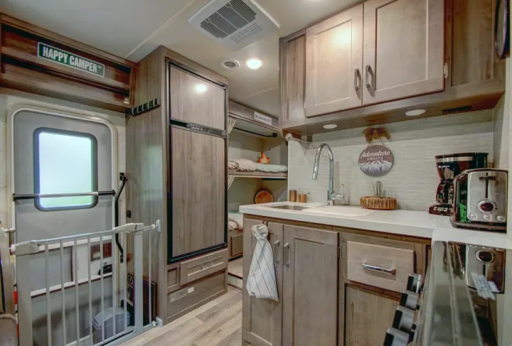 This RV rental features a cozy interior with a well-appointed kitchen, large fridge, and bunkhouse beds.. Winnebago Minnie Winnie 2021