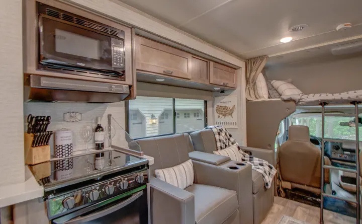 Explore this RV rental's spacious interior: full kitchen, comfy recliners, and an over-cab bunk. Ready for adventure!. Winnebago Minnie Winnie 2021