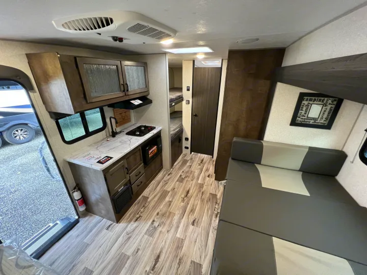 RV rental interior: full kitchen, convertible dining/sleeping area, and bunk beds. A functional, cozy travel space.. Sonic Lite 2022