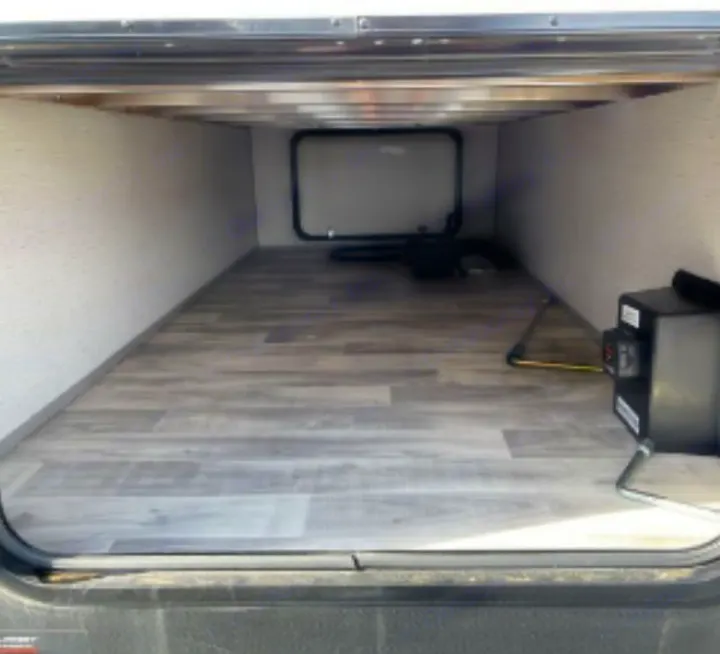 Explore this spacious RV rental's pass-through storage bay, featuring wood-look flooring for your travel essentials.. Dutchmen Kodiak SE 2023