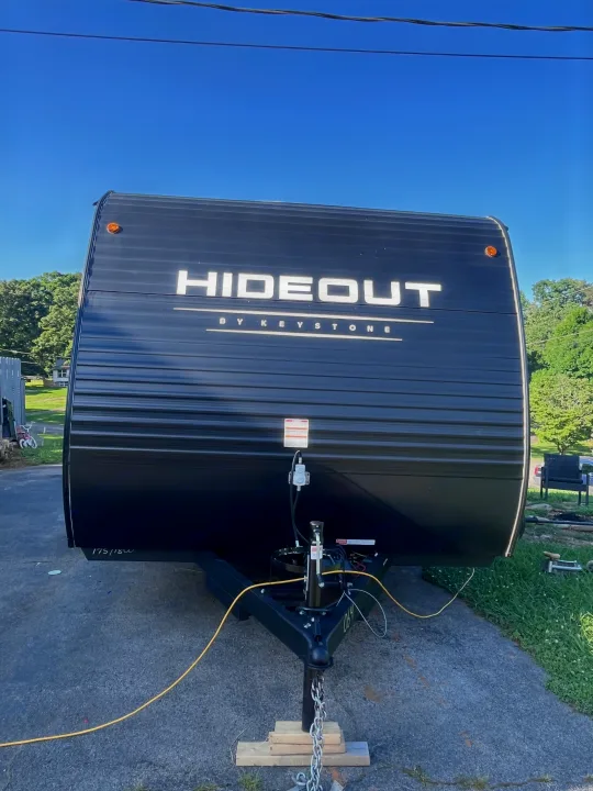Front view of a sleek black Hideout by Keystone travel trailer. Ready for your next RV rental adventure.. Keystone RV Hideout Sport 2024