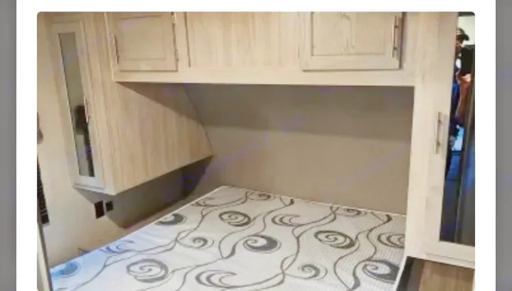 RV rental: Compact bedroom interior featuring a patterned mattress, overhead cabinets, and a mirrored wardrobe.. Coachmen Catalina Legacy 323BHDSCK 2022