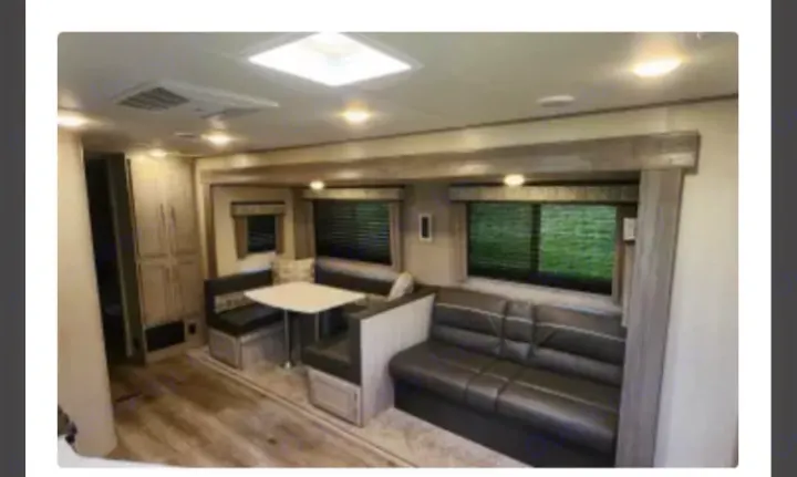 Spacious RV rental interior with a comfortable sofa, U-shaped dinette, and ample storage, ready for your next adventure.. Coachmen Catalina Legacy 323BHDSCK 2022