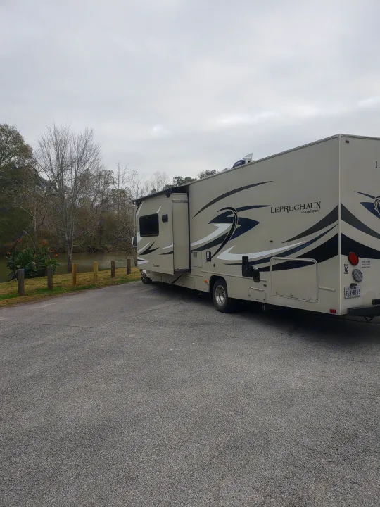 This Coachmen Leprechaun RV rental is parked by a river, ideal for camping and outdoor travel.. Forest River Coachmen Leprechaun 2015