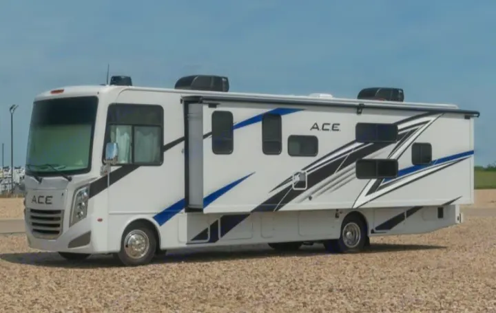 A white A.C.E. rv rental with sharp blue and black graphics, parked on a gravel lot. Ready for your next travel adventure.. Thor Motor Coach A.C.E 2024