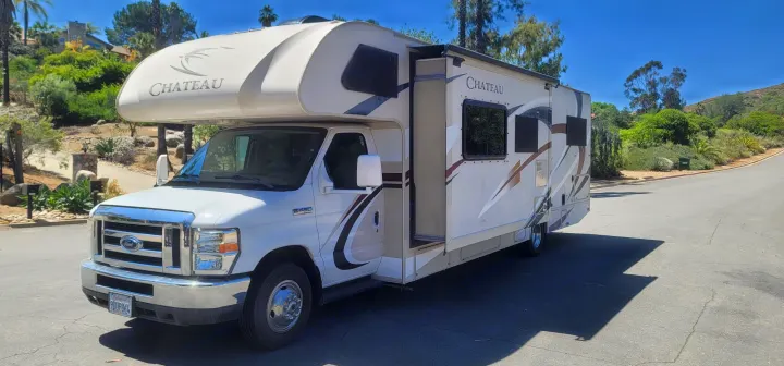 White Ford Chateau Class C RV rental features an extended slide-out on a sunny day, perfect for your next motorhome trip.. Thor Chateau 2018