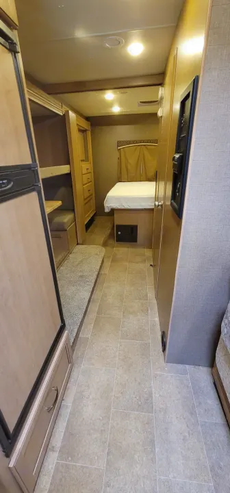 RV rental interior: cozy bedroom, bunk beds, dinette, and fridge in a compact layout. Perfect for travel.. Thor Chateau 2018