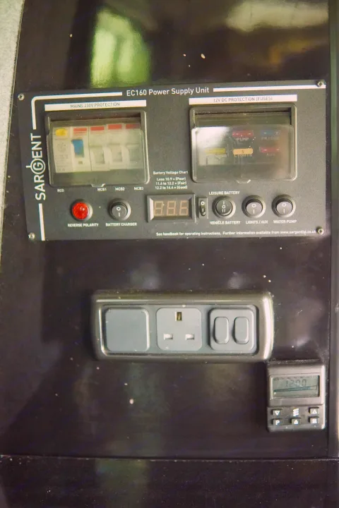 Sargent EC160 power unit for an rv rental, displaying fuses, battery voltage, UK outlet, and control switches.. Volkswagen T5 premium camper 2011