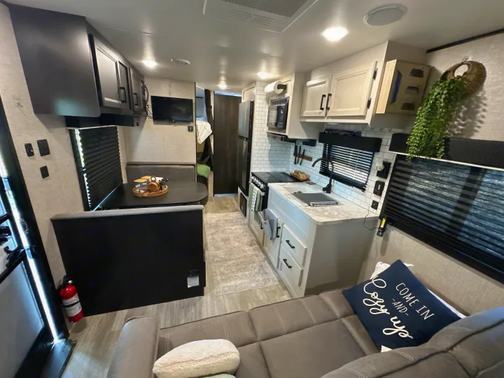 This RV rental showcases a modern interior with a well-equipped kitchen, comfy dinette, and a spacious living area.. Jayco Jay Flight 2023