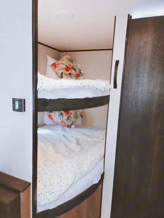 RV rental: Charming bunk beds with bright confetti bedding & tropical pillows for a cozy stay.. Jayco Jay Flight SLX 2024