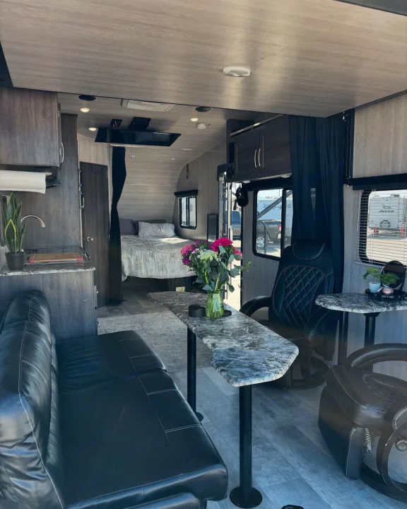 Spacious RV rental interior with a living area, compact kitchen, and rear bedroom setup.. Genesis Supreme Rv Genesis Supreme 2022