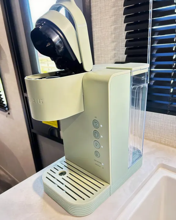 A compact light green Keurig single-serve coffee maker on an RV rental kitchen counter.. Jayco Jay Flight 2023