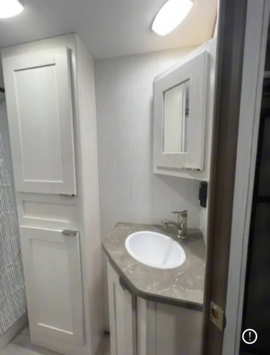 Compact, modern RV rental bathroom features a clean vanity, sink, medicine cabinet, and tall storage for your travels.. Cruiser RV MPG 2023