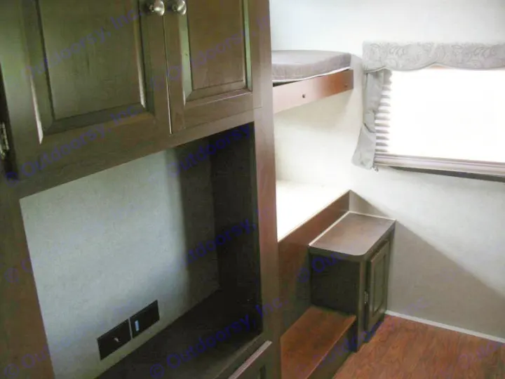 Experience comfort in this **rv rental**! Dark wood cabinets, a cozy bunk bed, and a window with blinds make a snug camper interior.. Forest River Rockwood Signature Ultra Lite 2015