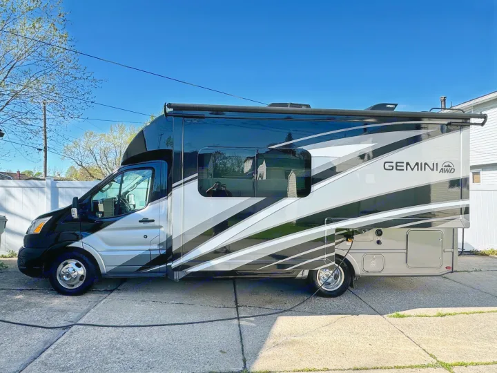 Explore this sleek Gemini AWD RV rental motorhome, parked on a sunny day, for your next travel adventure.. Thor Gemini 2022
