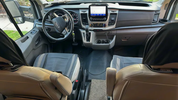 Explore this clean RV rental van's cockpit, showcasing its modern dashboard, screen, and comfortable seats.. Thor Gemini 2022