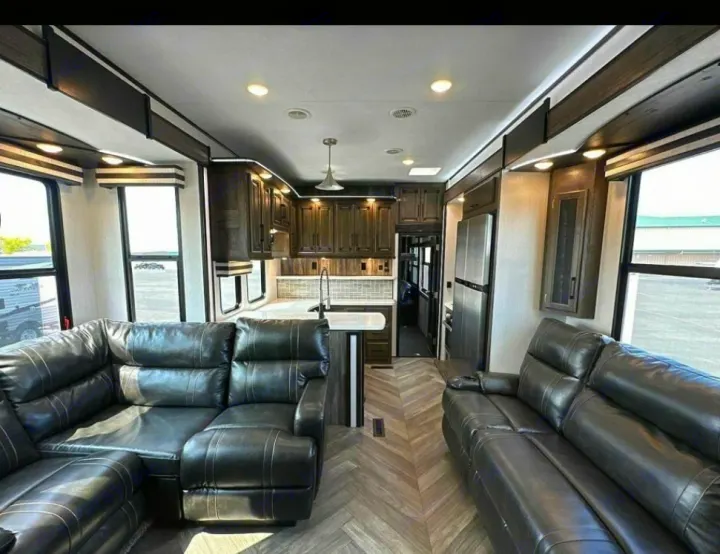 Spacious RV rental interior: modern kitchen with stainless steel fridge and comfortable leather sofas.. Heartland Cyclone 2022