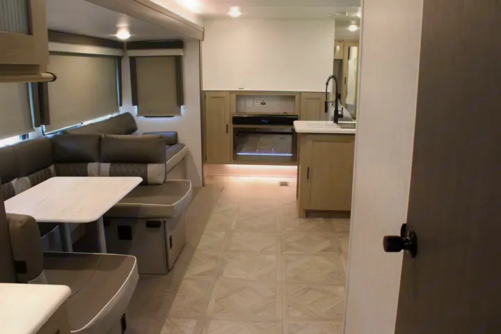 RV rental: A modern interior featuring a comfy dinette, kitchenette, glowing fireplace, and patterned floor.. Forest River Wildwood Platinum 2024
