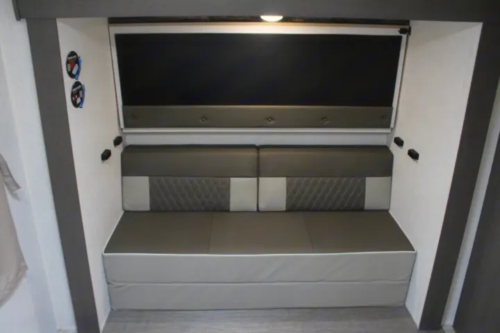 RV rental: Versatile interior with convertible seating/bed, pull-down screen, and wall controls.. Forest River Wildwood Platinum 2024