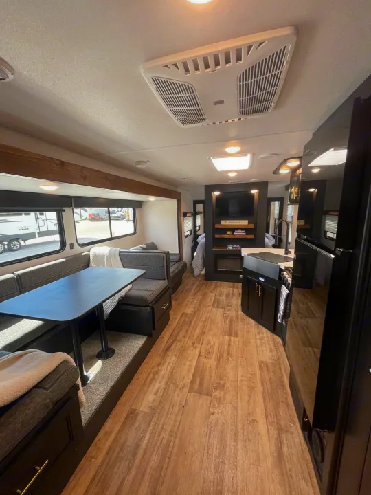 Explore this RV rental's spacious interior: a cozy dinette, modern kitchen, and entertainment wall.. Forest River Cherokee Grey Wolf 2022