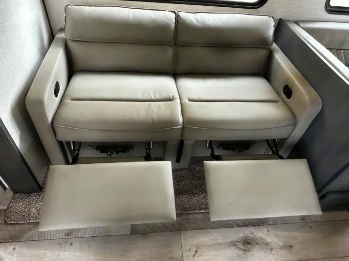 RV rental: A light-colored dual reclining sofa with both footrests extended, offering comfort in this RV interior.. Aspen Trail Aspen Trail Trailer 2022