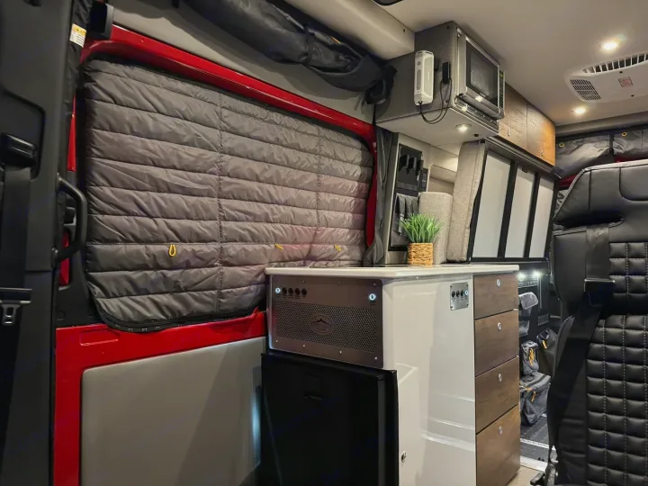 Explore this modern rv rental interior, featuring an equipped kitchenette, cozy seating, and insulated window shades.. Storyteller Overland Beast Mode AWD 2024