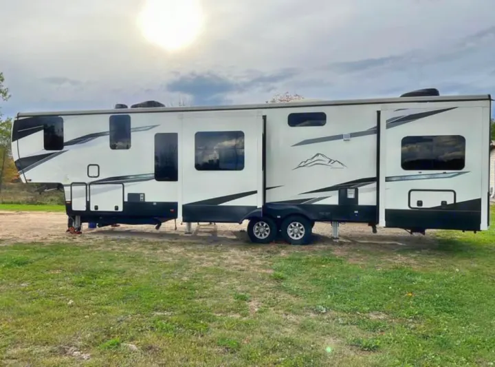 Spacious white and black fifth wheel RV rental with extended slide-outs, parked in an outdoor setting. Ready for your next adventure.. Heartland RVs Big Country 2021