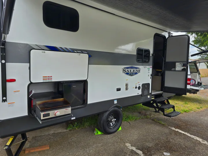 This RV rental travel trailer features a convenient outdoor kitchen with a griddle and mini-fridge, perfect for camping.. Forest River Salem FSX 2024
