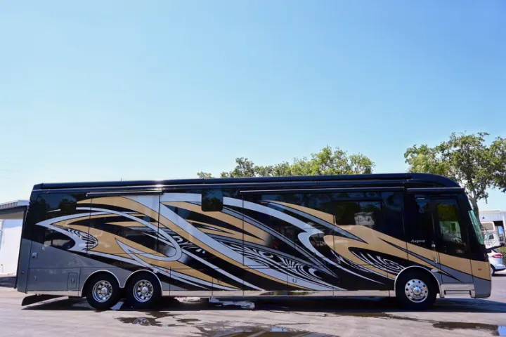 A striking black, gold, and silver Aspire luxury motorhome, ideal for an upscale RV rental experience.. Entegra Coach Aspire 2019