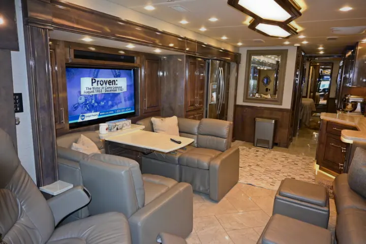 Luxury RV rental interior: spacious living area with plush leather seating, entertainment, and a well-equipped kitchen.. Entegra Coach Aspire 2019