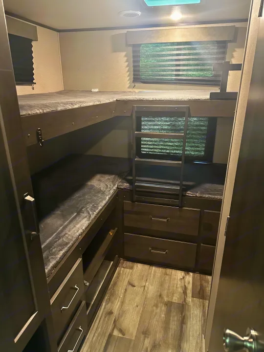 Experience comfort in this RV rental! Bunk beds with soft bedding, a ladder, and storage drawers. Perfect for families.. Grand Design Transcend Xplor 2022