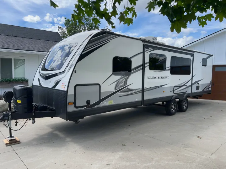 White Hawk travel trailer (RV rental) parked on a driveway, ready for adventure and camping.. Jayco White Hawk 2022