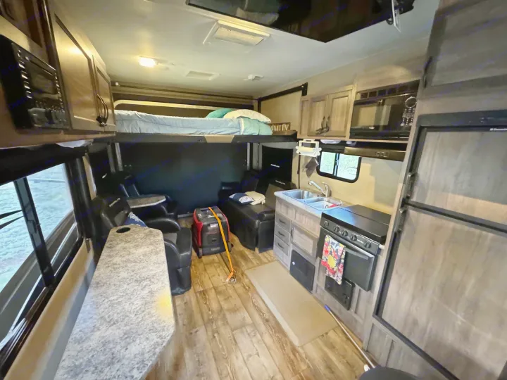 RV rental interior with a kitchen, bunk bed, and living space. Ideal for travel or camping adventures.. Pacific Coachworks Blaze'N 2017