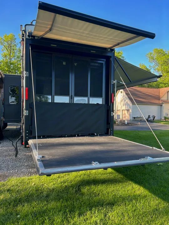 An RV rental showing its rear ramp lowered as a patio, with an extended awning and screen doors, ready for outdoor enjoyment.. Raptor Raptor 2017
