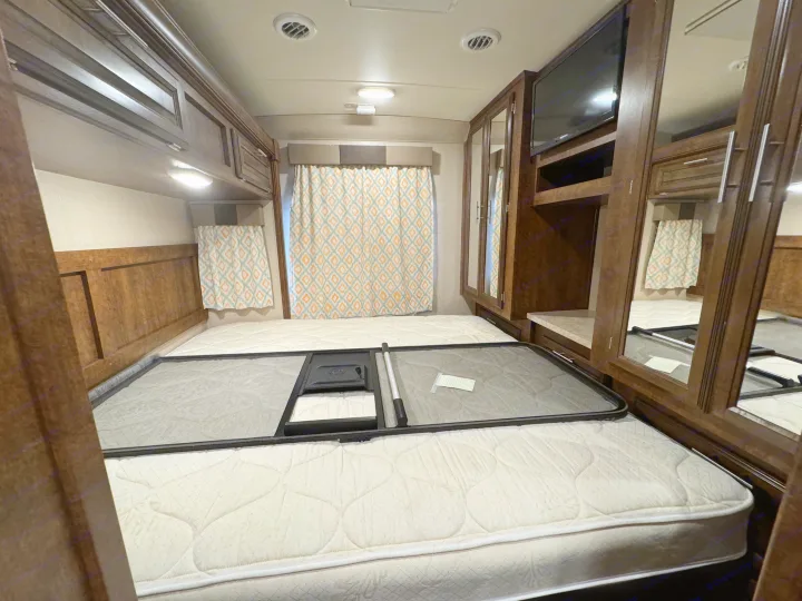 RV rental bedroom: a comfy mattress, raised bed base, overhead cabinets, TV, and mirrored closet. Ready for your trip!. Forest River FR3 2016