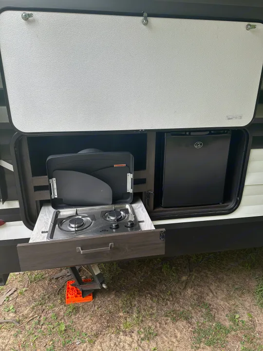 This RV rental features an outdoor kitchen: a pull-out counter with a two-burner stove and a compact mini-fridge.. Grand Design Transcend Xplor 2022