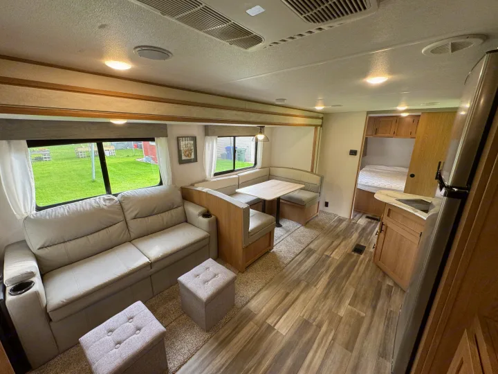 Modern and spacious RV rental interior featuring a comfy living area with sofa, dinette, kitchen, and bedroom. Perfect for travel.. Prime Time Avenger 2022