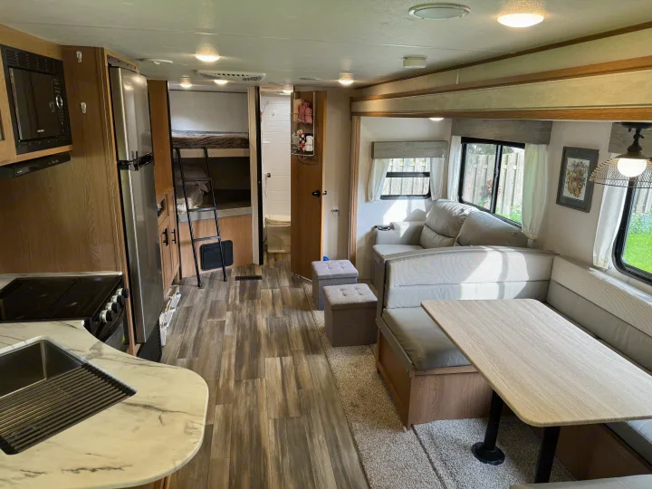 This rv rental offers a full kitchen, dining area, bunk beds, and bathroom in a bright, modern interior.. Prime Time Avenger 2022