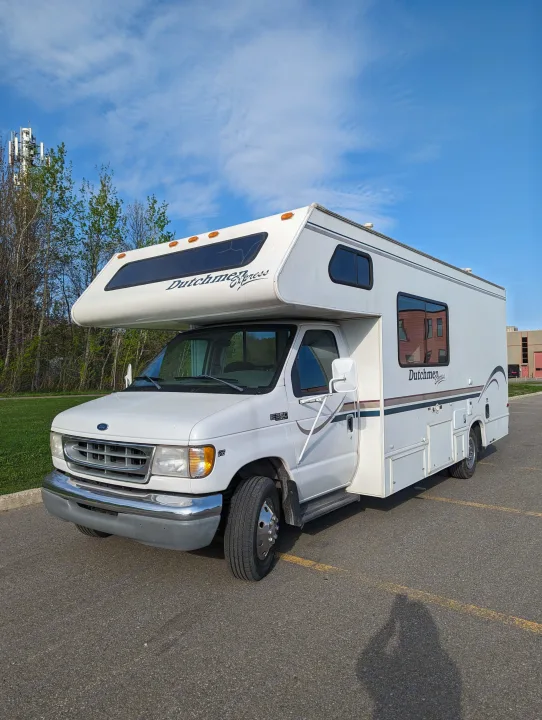 This Class C Dutchmen Express RV, ideal for rv rental, is parked outdoors on a sunny day.. Ford Ford 2001