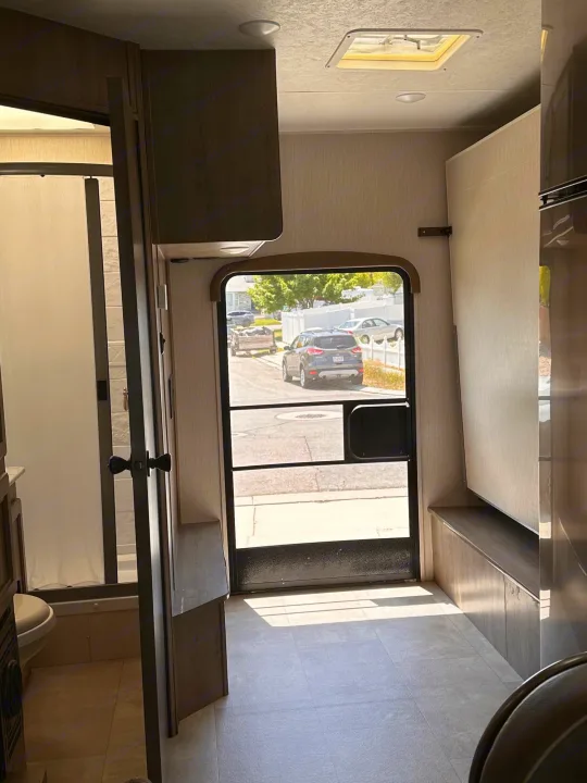 RV rental: View inside a modern camper, featuring the main entry door, bathroom, and versatile living space.. Coachmen Freelander 2020